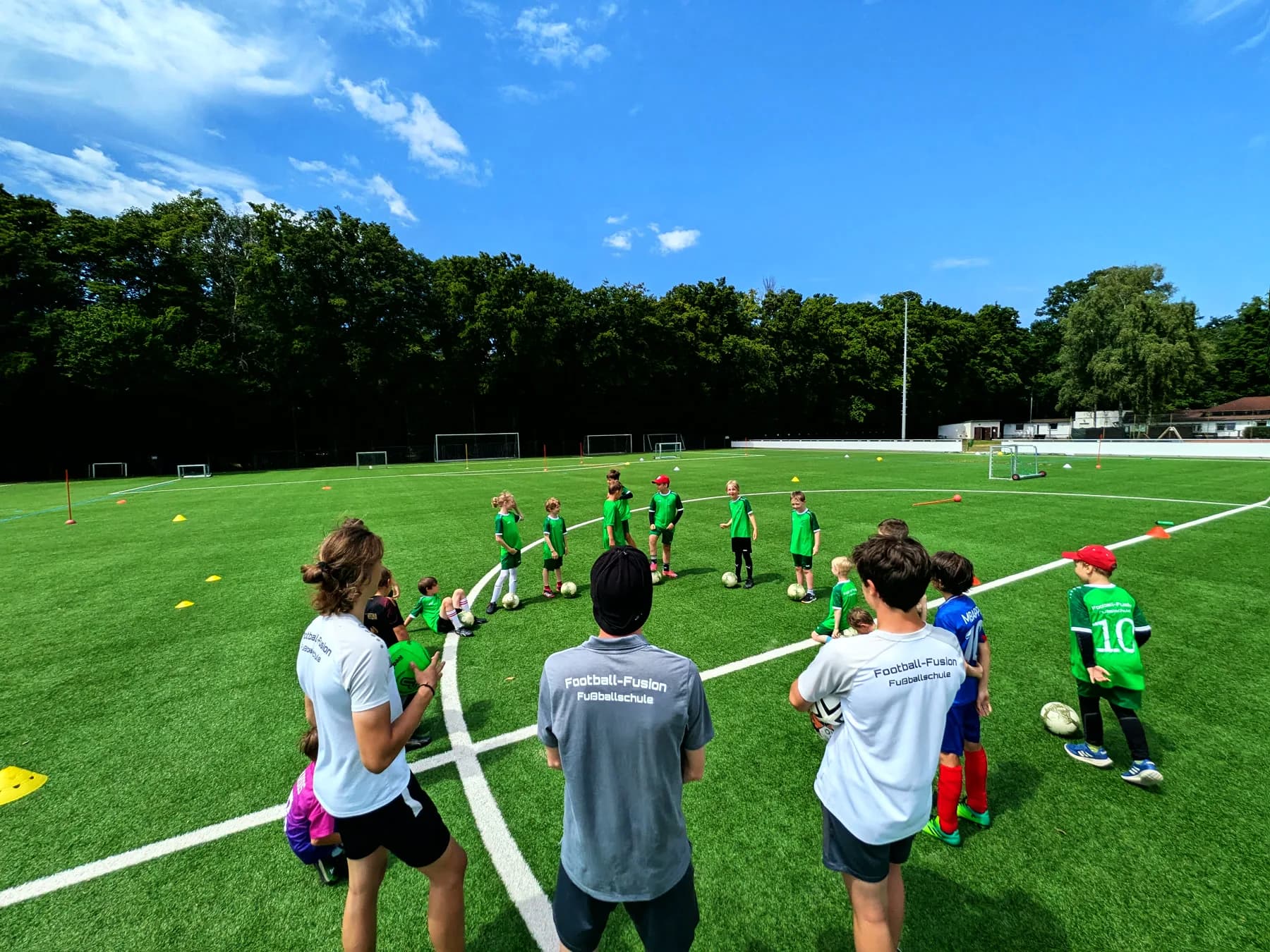 Trainingsgruppe im Kreis auf dem Rasenplatz